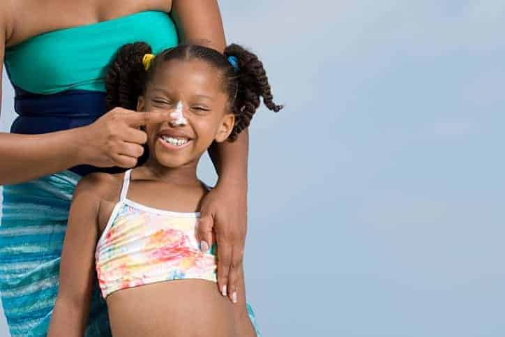 Mother Applying Sunscreen to Daughters Nose