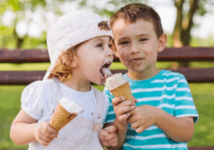 little girl and boy sharing ice cream